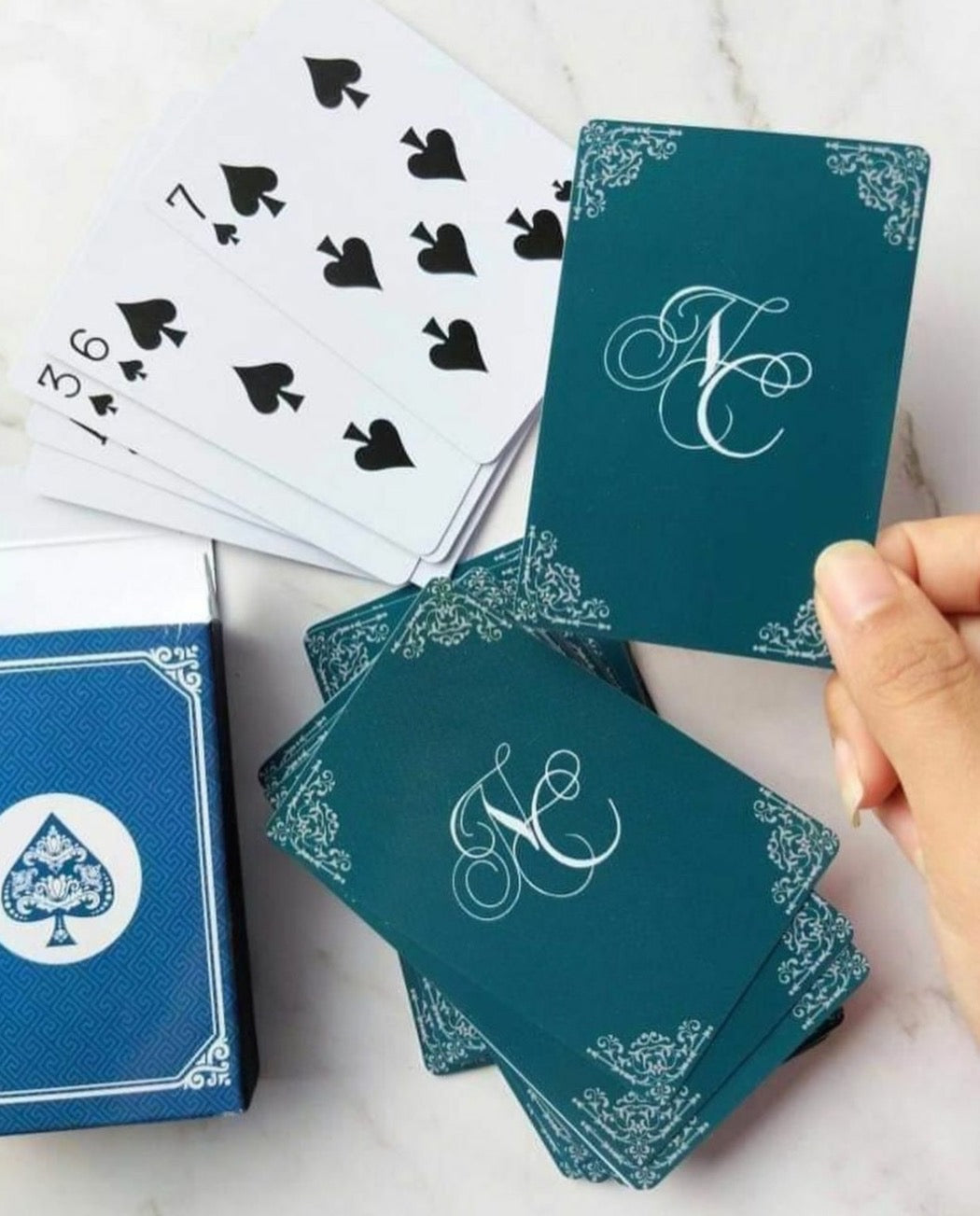 A deck of playing cards with a personalized logo and the number cards