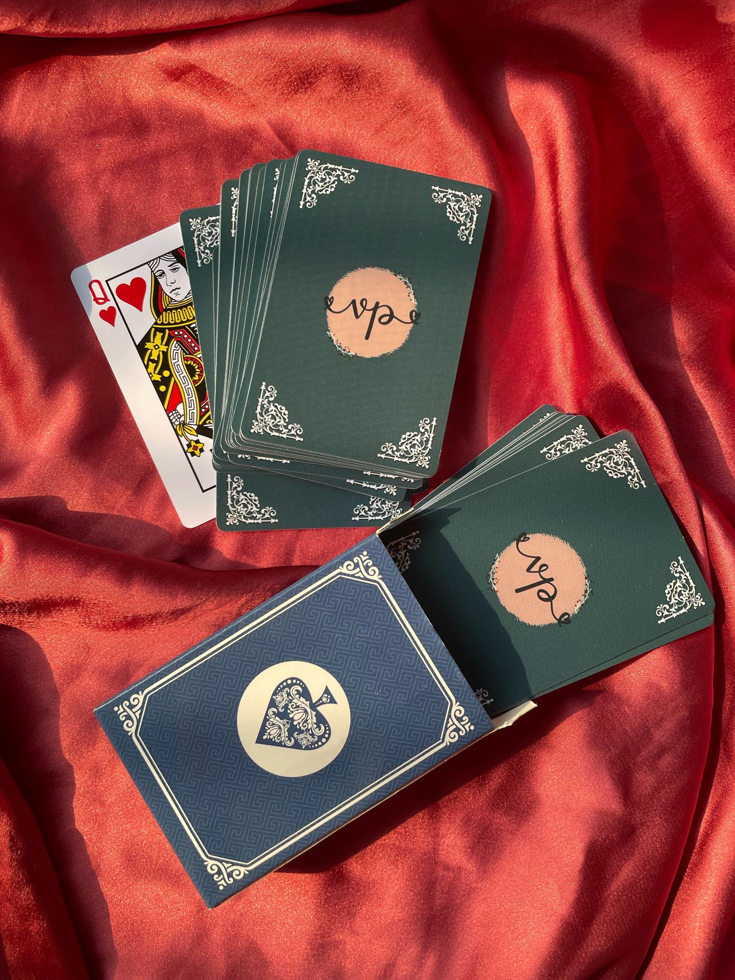 A deck of custom playing cards spread out, showing the back of the cards with a personalized design logo and the face cards.