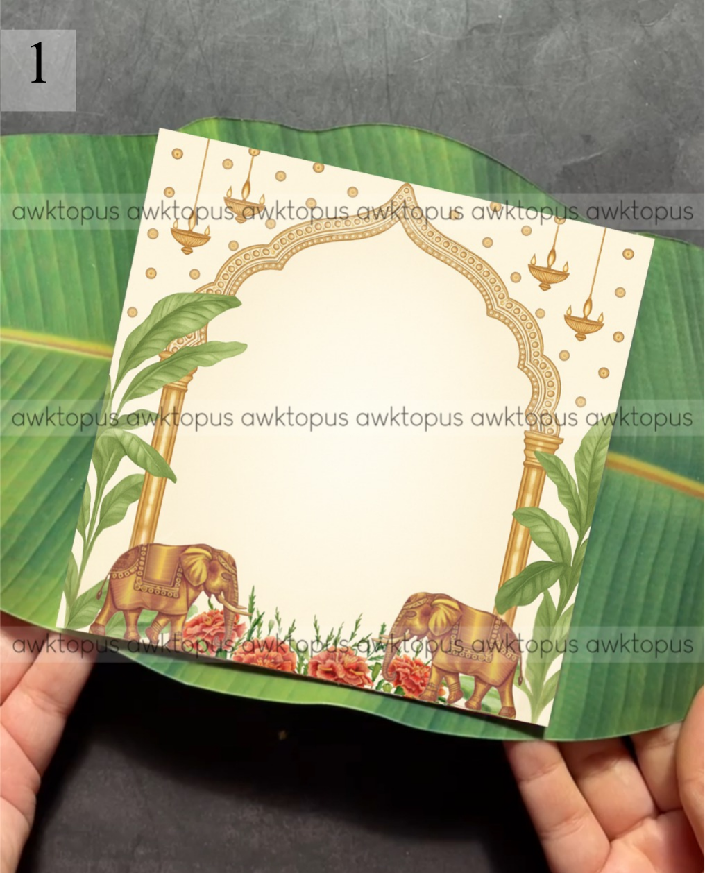 Card with elephants and floral design held by hands on a leaf background